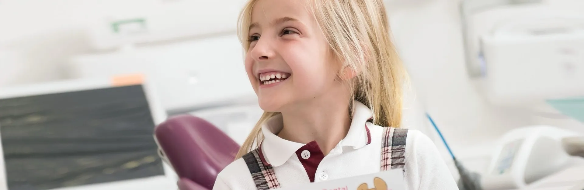 Niña sonriendo en el sillón dental de Enamel Clínica Dental